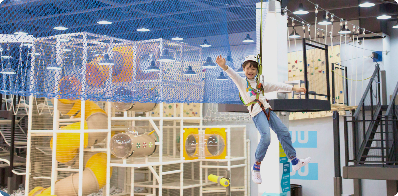 어린이가 헬멧쓰고 짚라인을 즐기는 모습