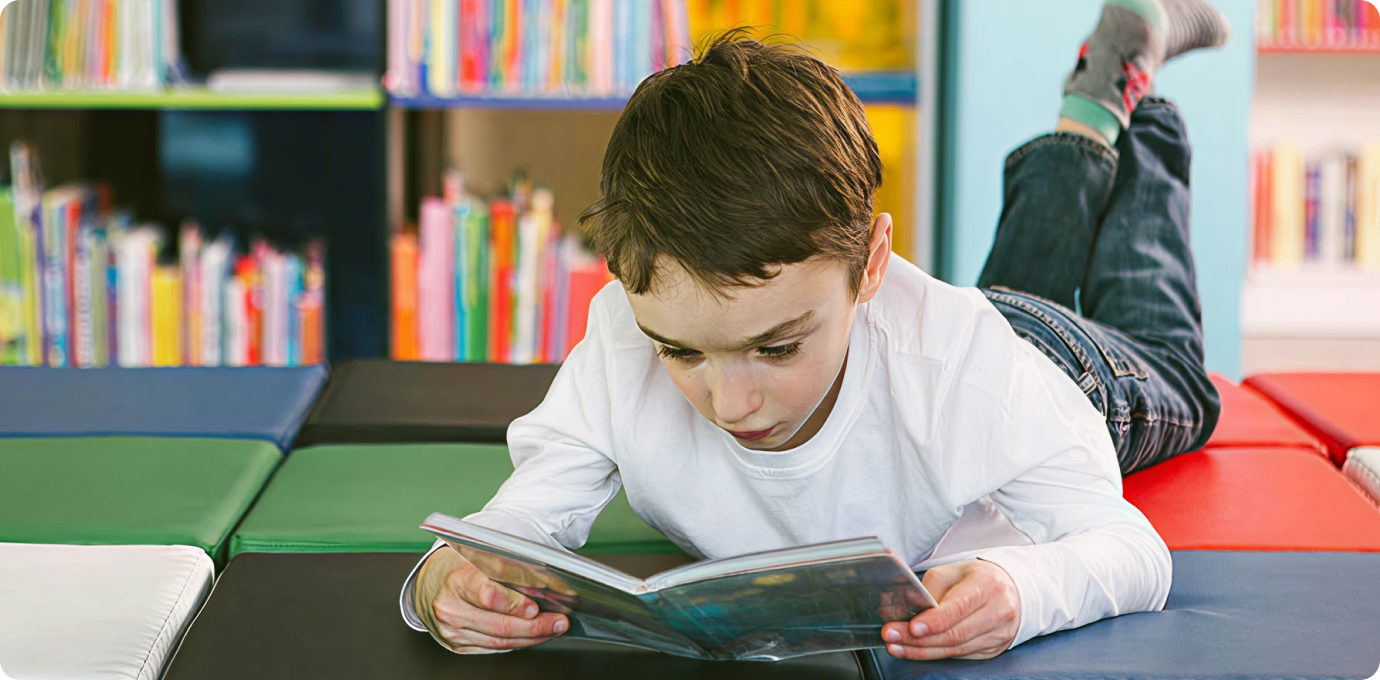 아이가 매트에 누워 책읽는 모습